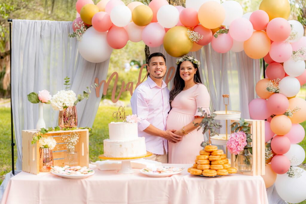 Lovely couple celebrating maternity outdoors with balloons and cake. Perfect for family joy and love themes.
