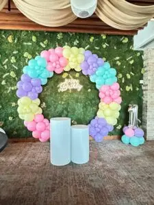 Colorful balloon arch birthday decoration with pastel and metallic balloons in a festive setup.
