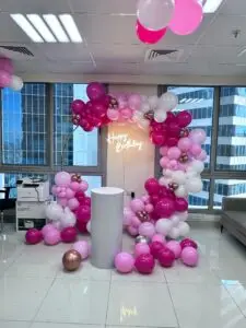 Pink and white balloon arch for birthday party decoration.